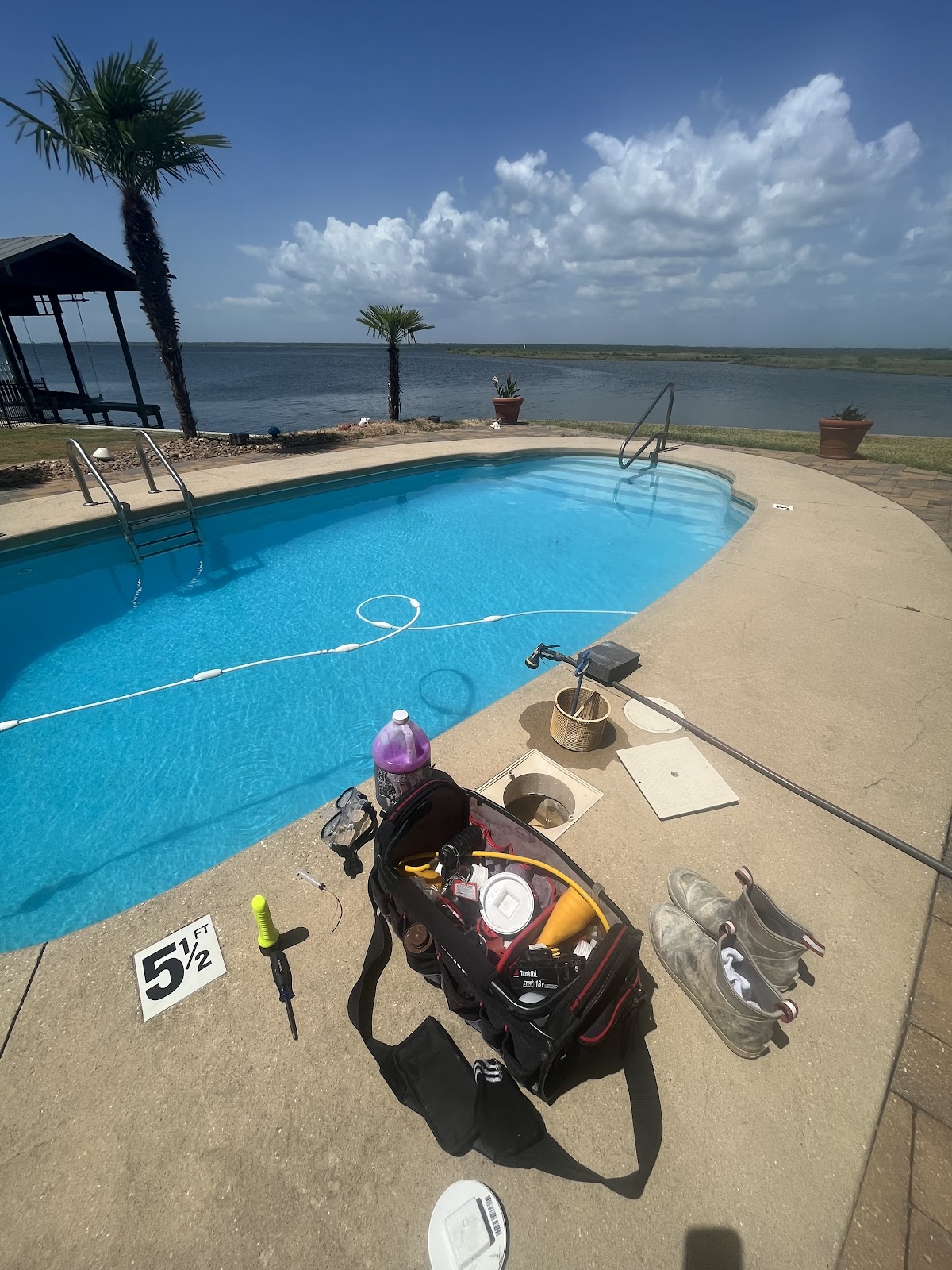 Pool leak-detection tools arranged beside a waterfront swimming pool